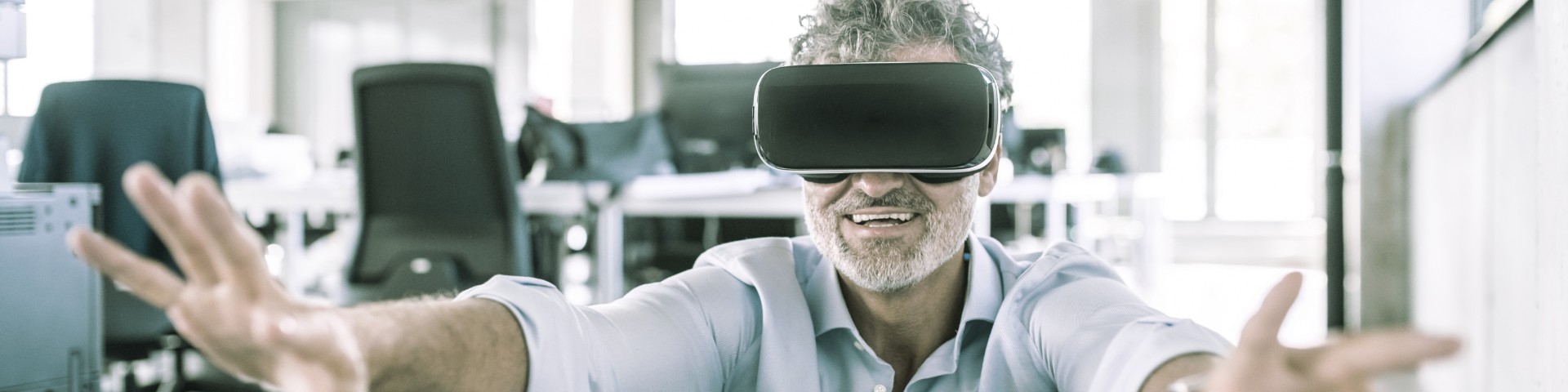 Ein Mitarbeiter probiert im Büro eine VR Brille aus